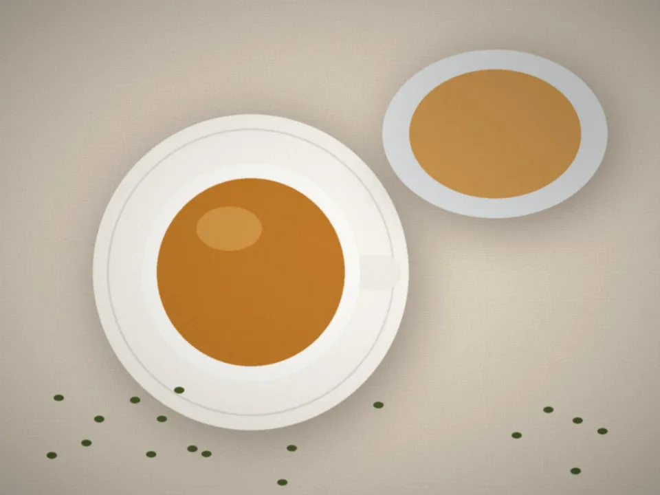 Tasse de thé et théière en verre sur une table claire