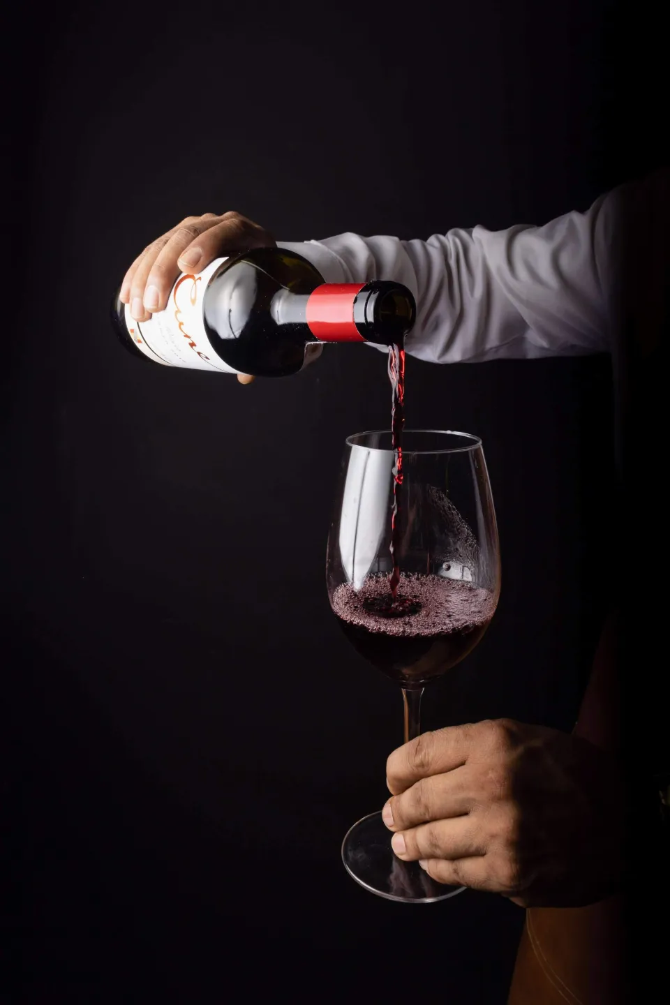 Le sommelier sert un verre de vin rouge