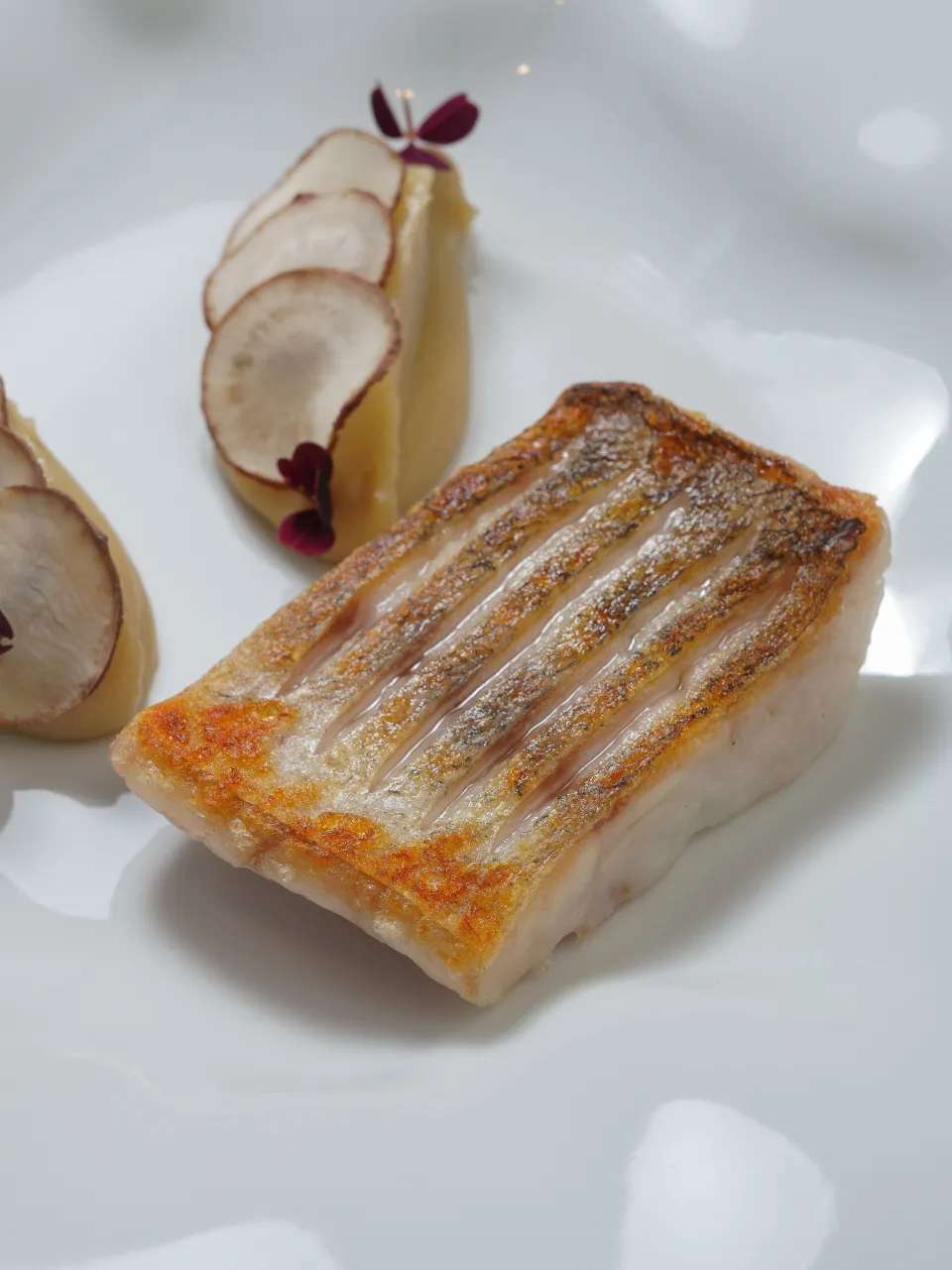 Poisson rôti sur assiette blanche