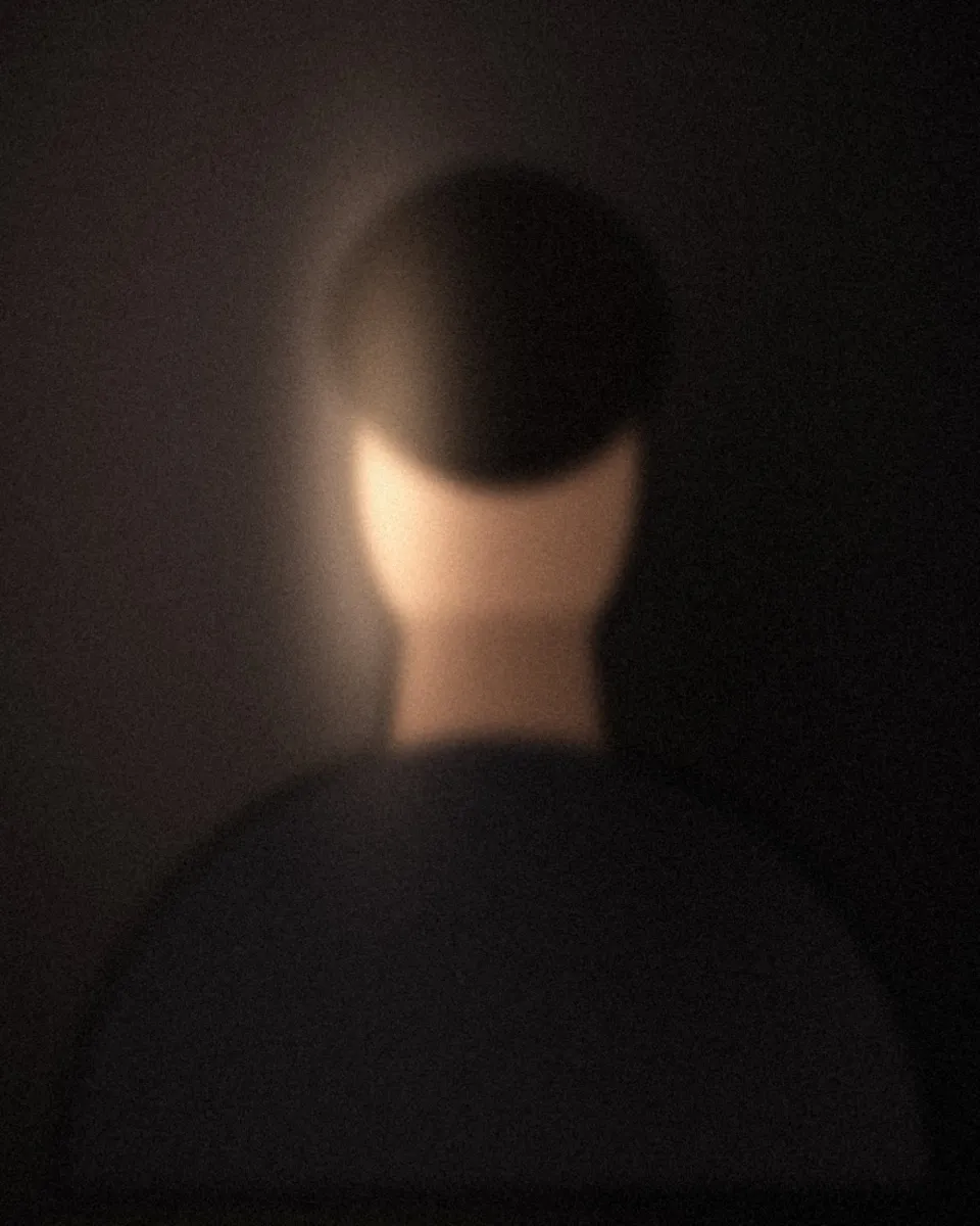 Portrait intimiste, visage éclairé de côté sur fond noir