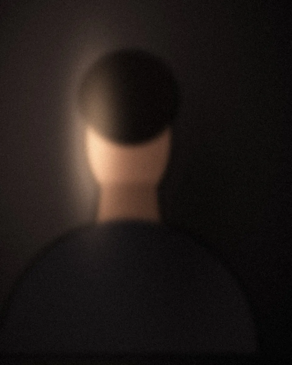 Portrait en clair-obscur sur fond sombre, lumière de fenêtre