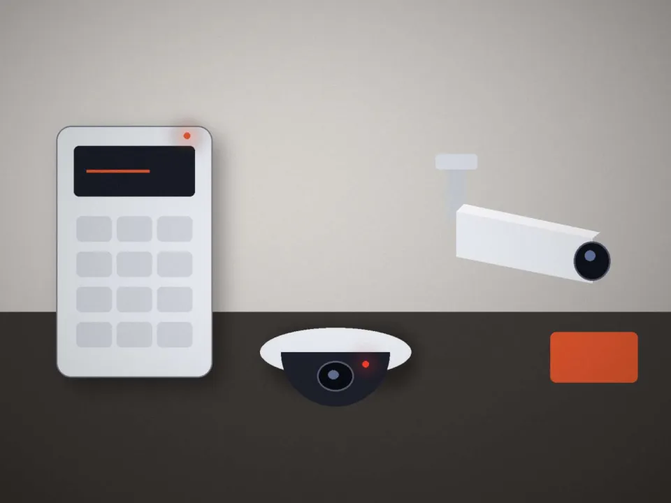 Clavier d'alarme, caméras et badge posés sur un plan de travail