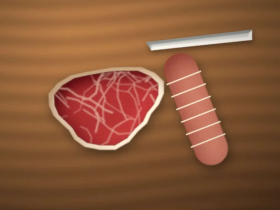 Le boucher découpe une pièce de bœuf sur le billot en bois